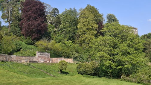 View across Georgian pleasure garden towards old glasshouse at Newark Park